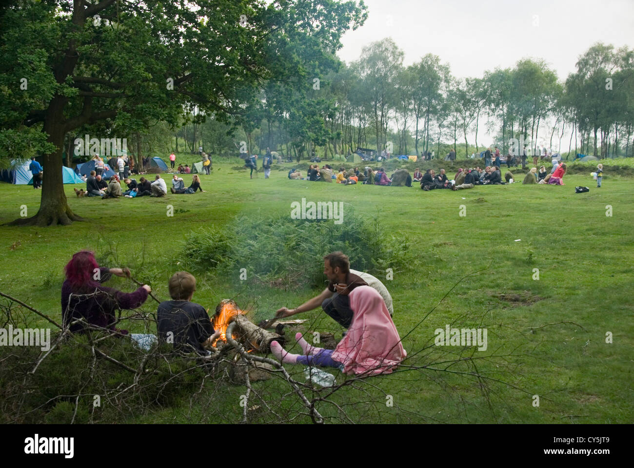 Family Sitting Around a Camp Fire as Crowds Gather to Celebrate the Summer Solstice at Nine Ladies Stone Circle, Stock Photo