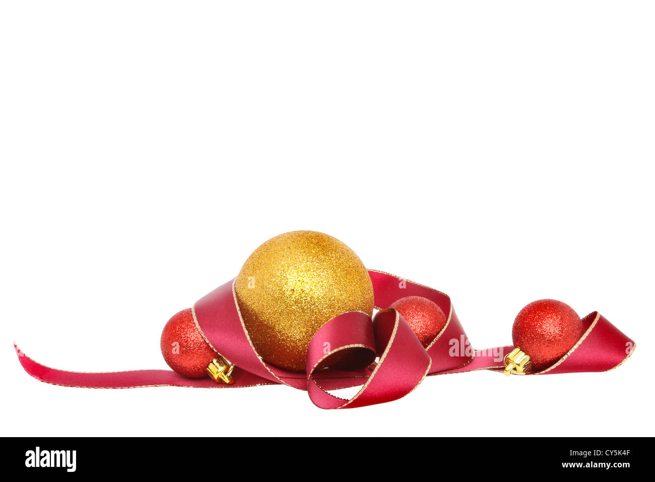 Christmas motif of gold edged red ribbon and gold and red baubles isolated against white Stock Photo