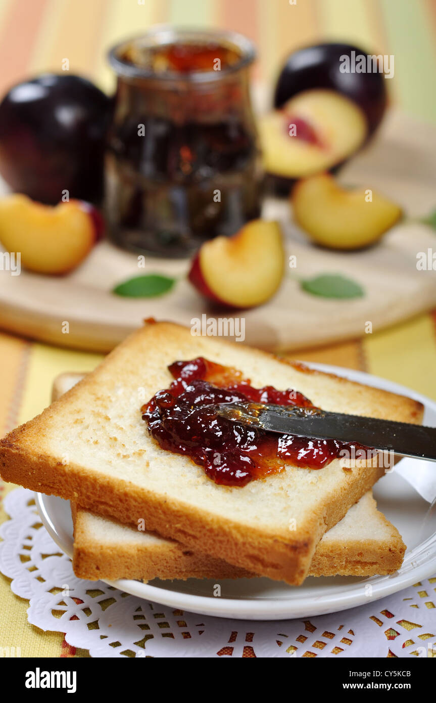 Plum jam with toast on white plate and fresh ripe plums.  Stock Photo