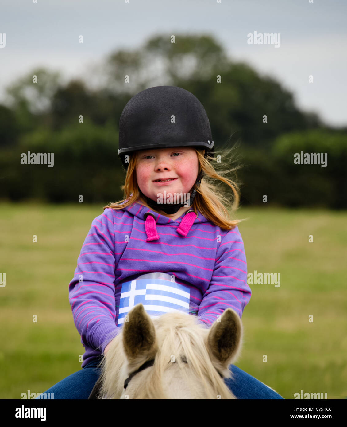 Young girl with Down Syndrome riding a horse Stock Photo