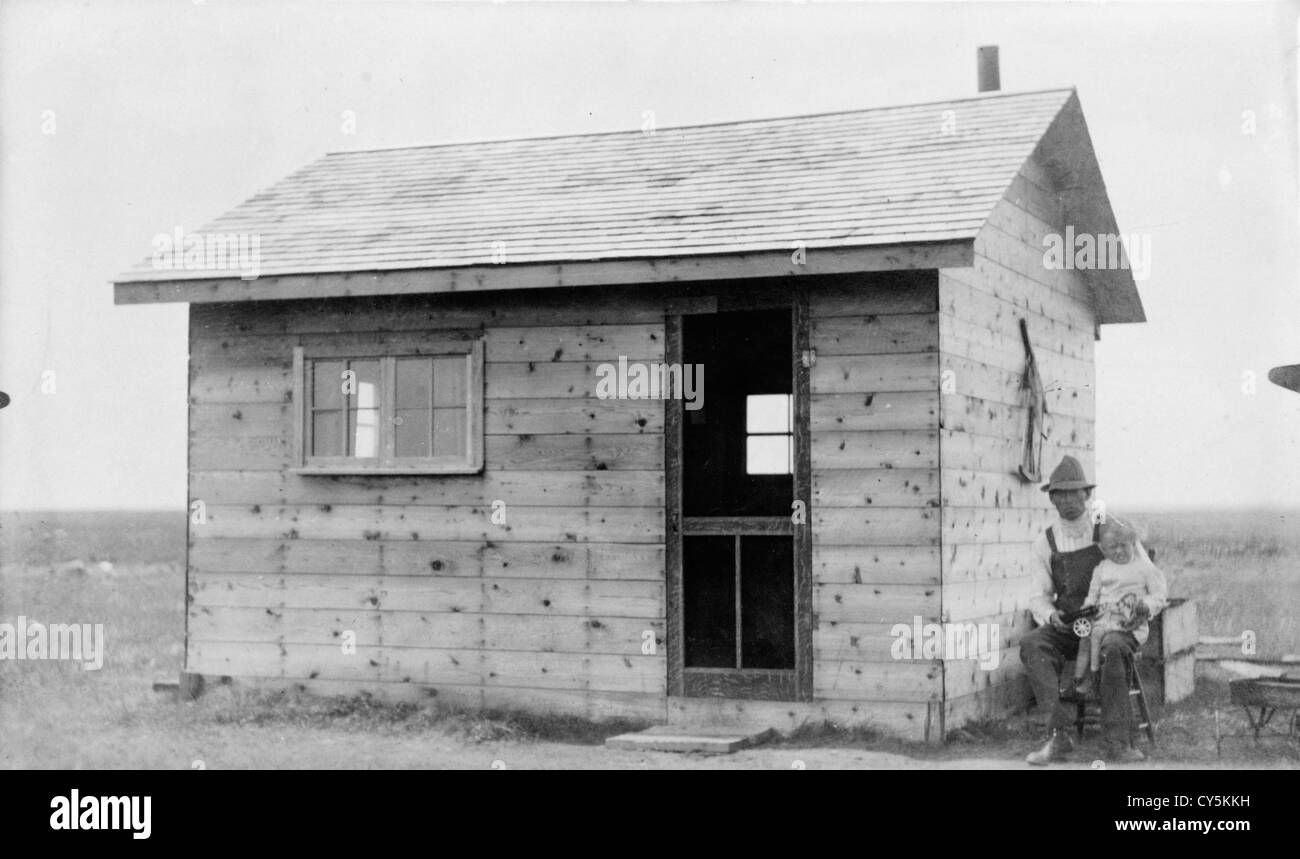 Homesteading, Luseland, Canada 1900s. Timber frame homestead cabin Saskatchewan. The Sykes family, father and son, this new timber home minus glass in the window frame door was on 53 acres of land that my grandfather had purchased.  HOMER WARWICK SYKES Stock Photo