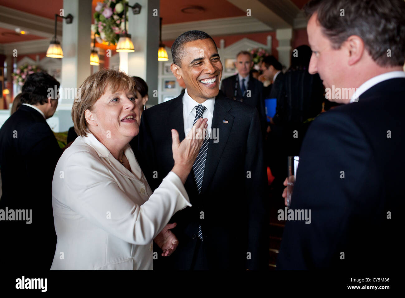 US President Barack Obama talks with German Chancellor Angela Merkel and British Prime Minister David Cameron before the start of the working G8 dinner May 26, 2011 in Deauville, France. Stock Photo