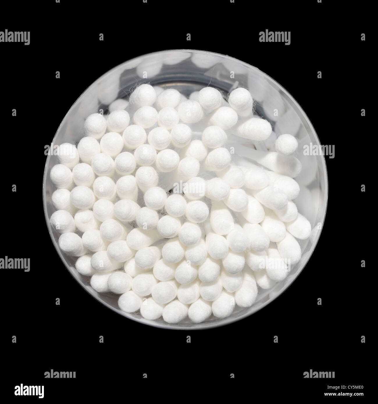 Cotton buds in a circular container viewed from above on a black background Stock Photo