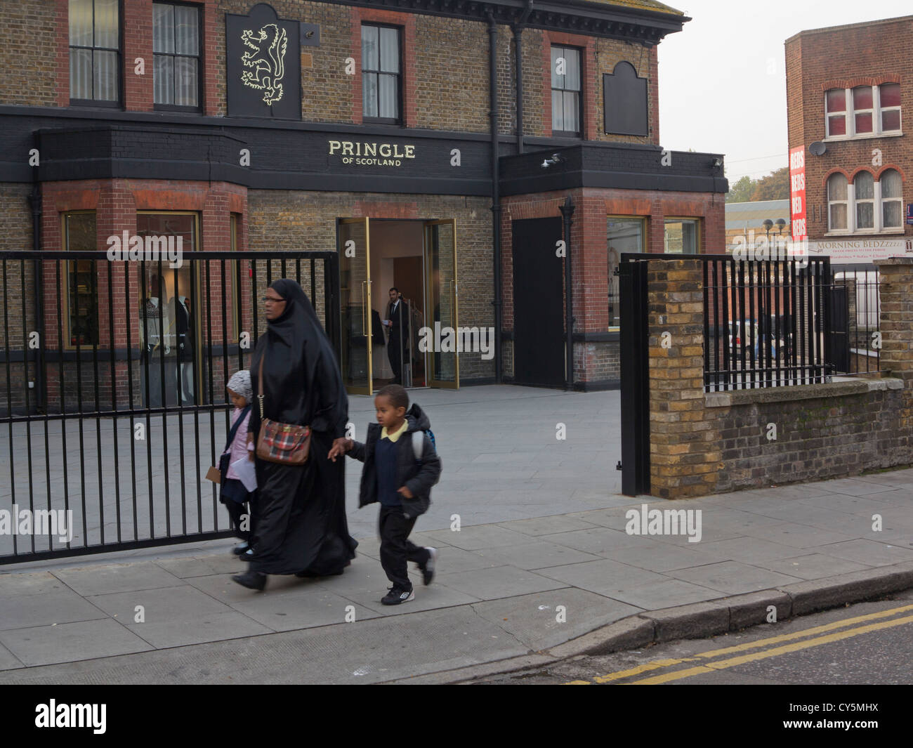 Local Muslim woman and children by luxury knitwear label Pringle of Scotland  new store in Hackney, London, by Burberry outlet Stock Photo - Alamy