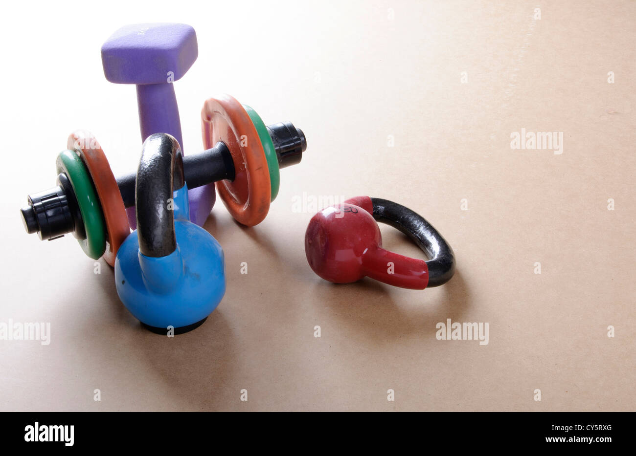 Kettle bells and Dumb bells on light plain floor Stock Photo