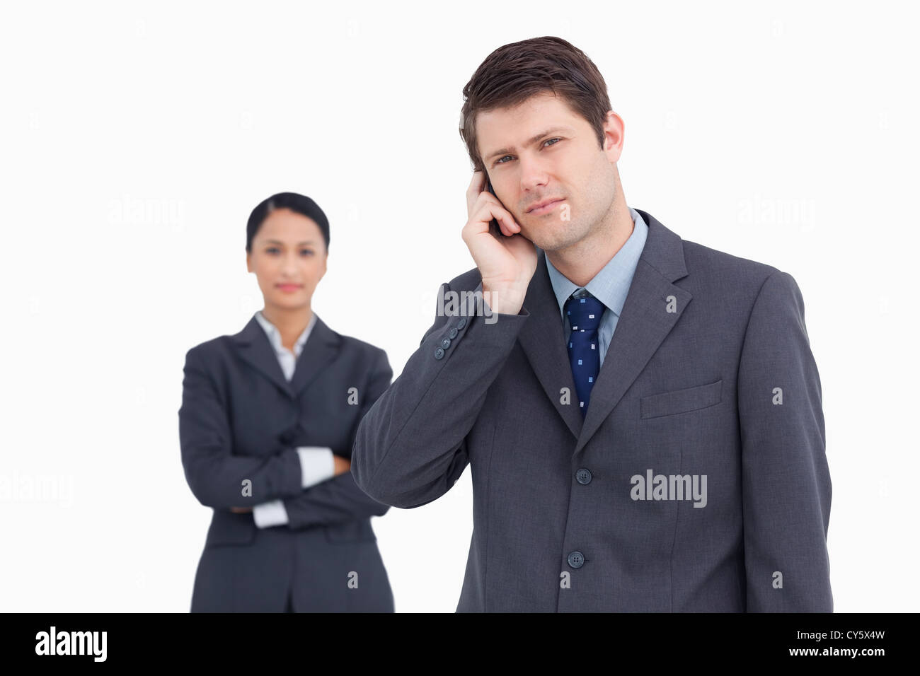 Close up of salesman on the phone with colleague behind him Stock Photo ...