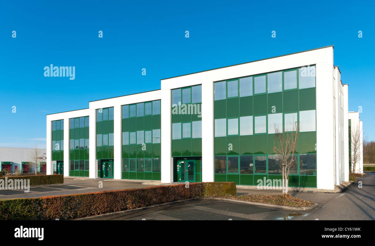 modern green office building against a blue sky Stock Photo