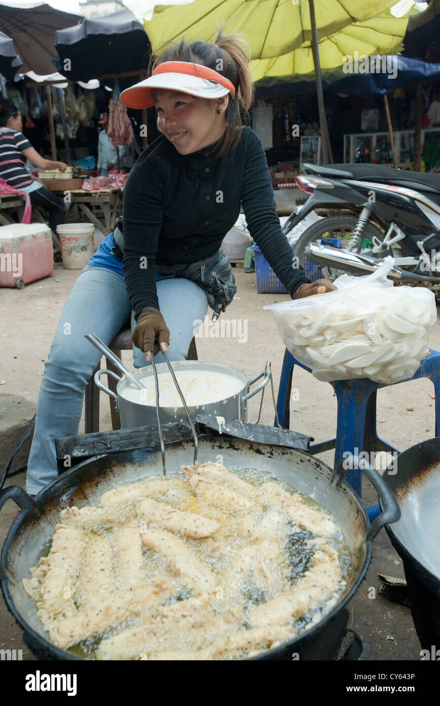 A Young market trader prepares deep fried vegetables in Sisophon