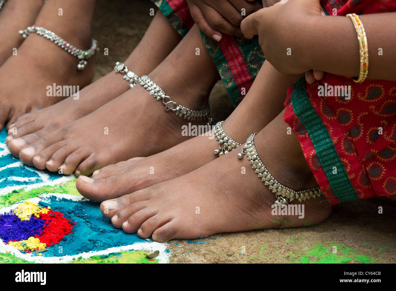Indian girls bare feet around a Indian rangoli peacock festival design ...