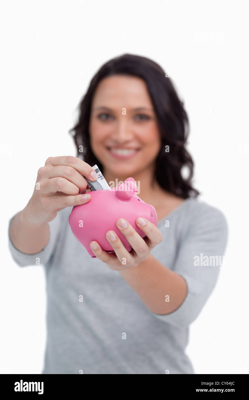 Money being put into piggy bank by woman Stock Photo - Alamy