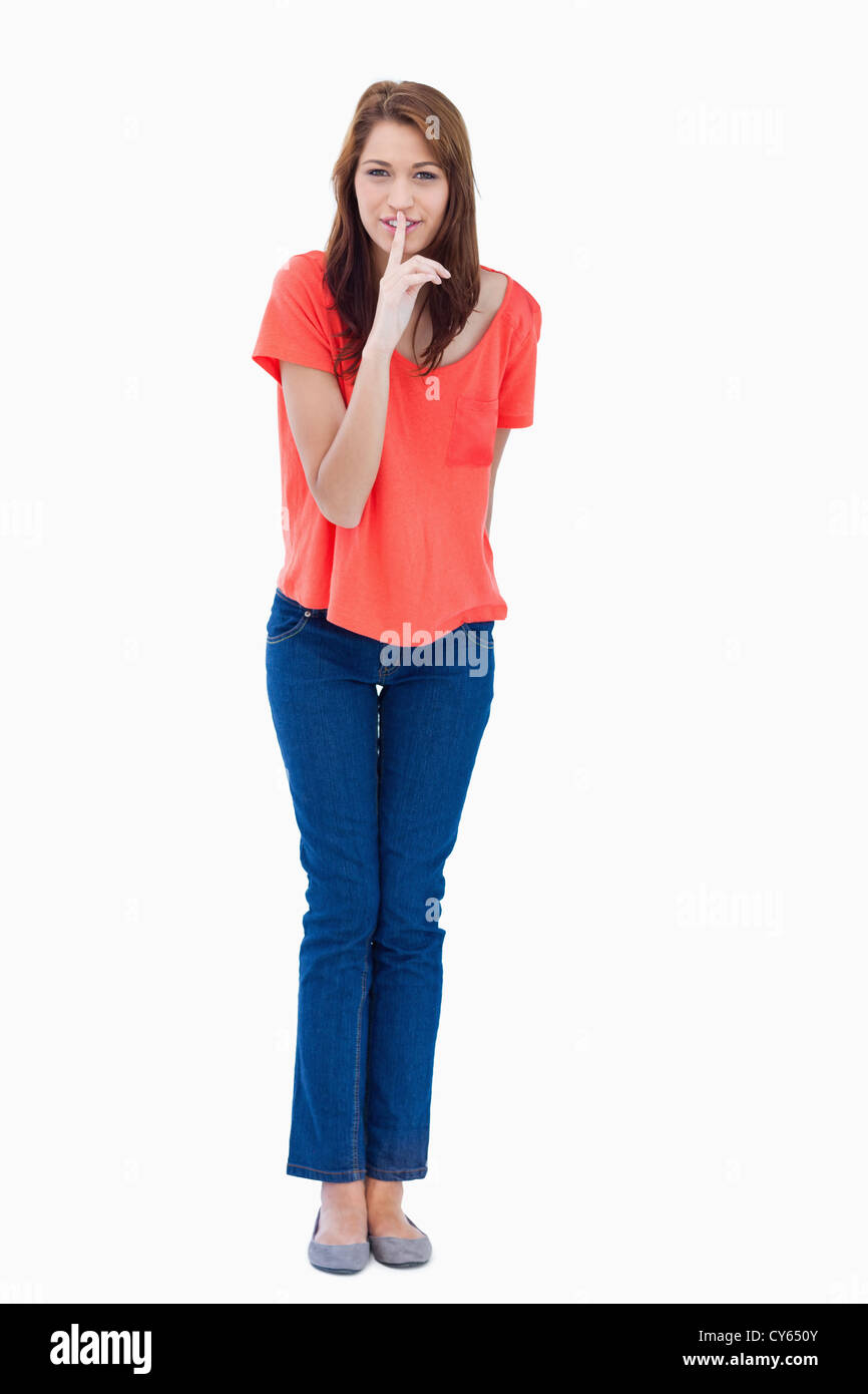 Young woman standing up while showing a quiet gesture Stock Photo Alamy
