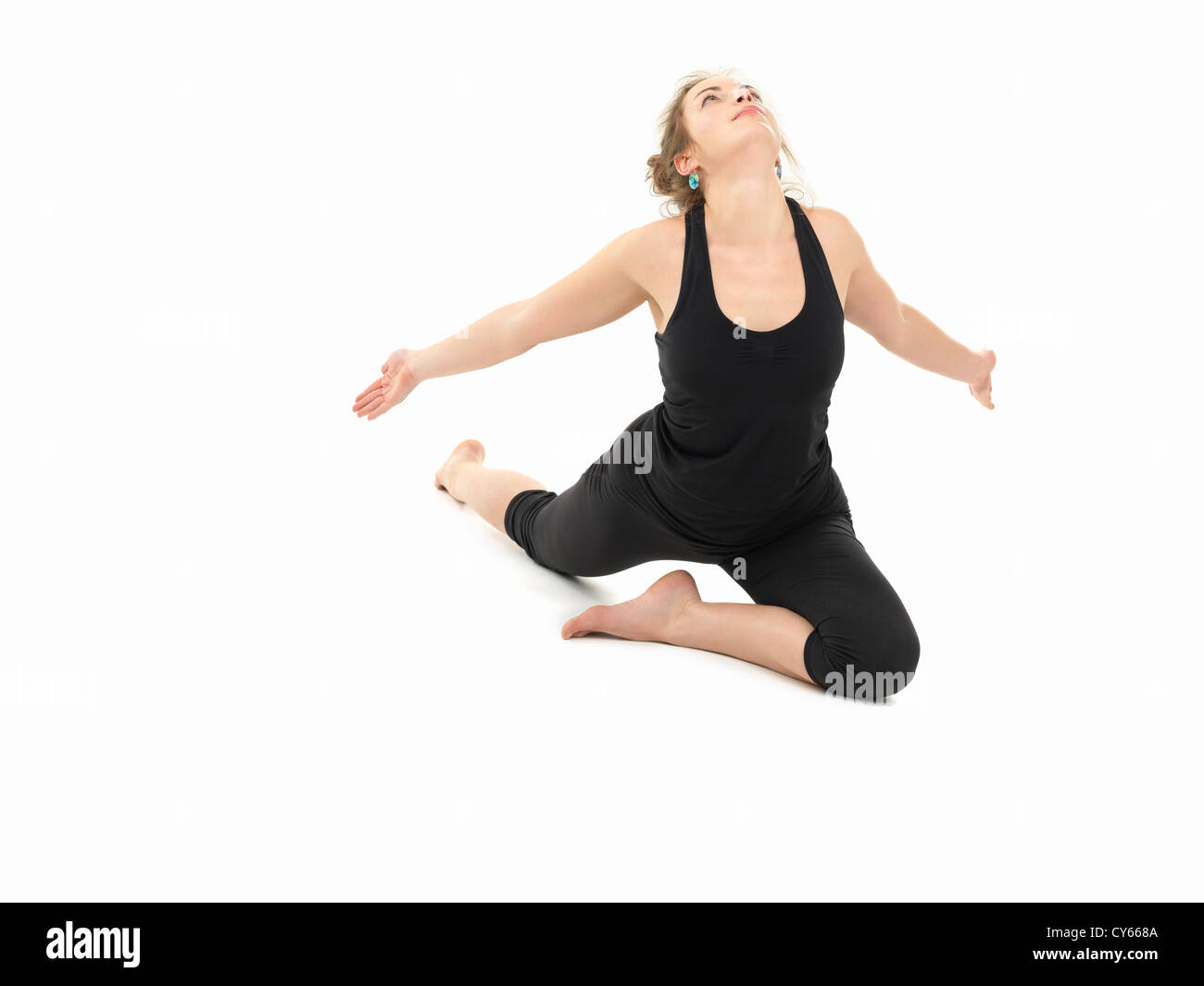 young slim girl in yoga pose, full frontal view, dressed in black, on white background Stock Photo