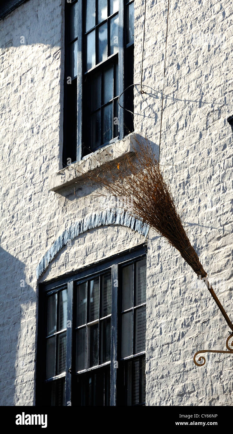 Georgian style sash windows and white painted brick wall with broom stick. Stock Photo