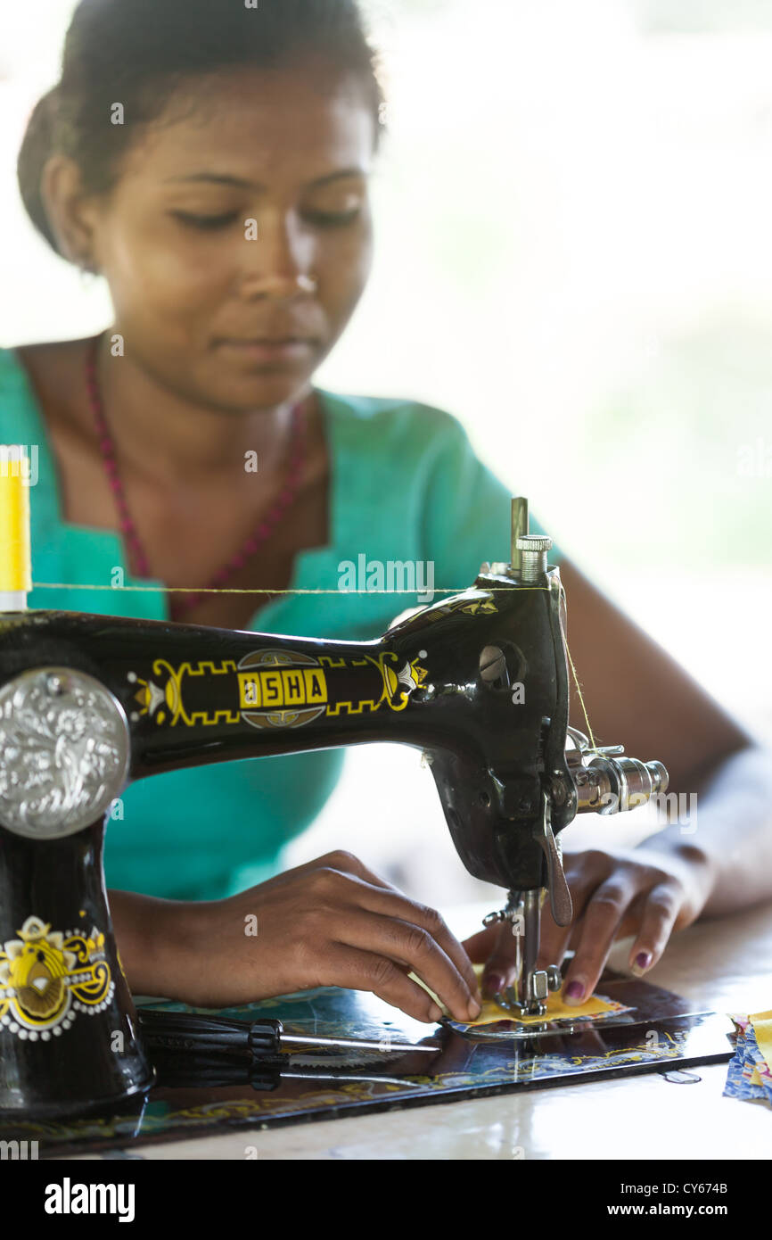 Local woman using sewing machine, village sewing project, Sapana