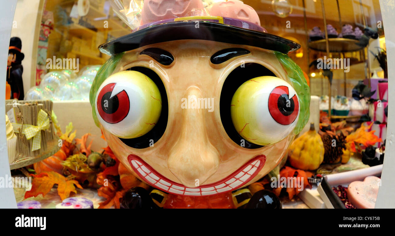Ceramic pot of an over sized head with large bulging eyes used in a shop window to sell fragrant soaps. Stock Photo