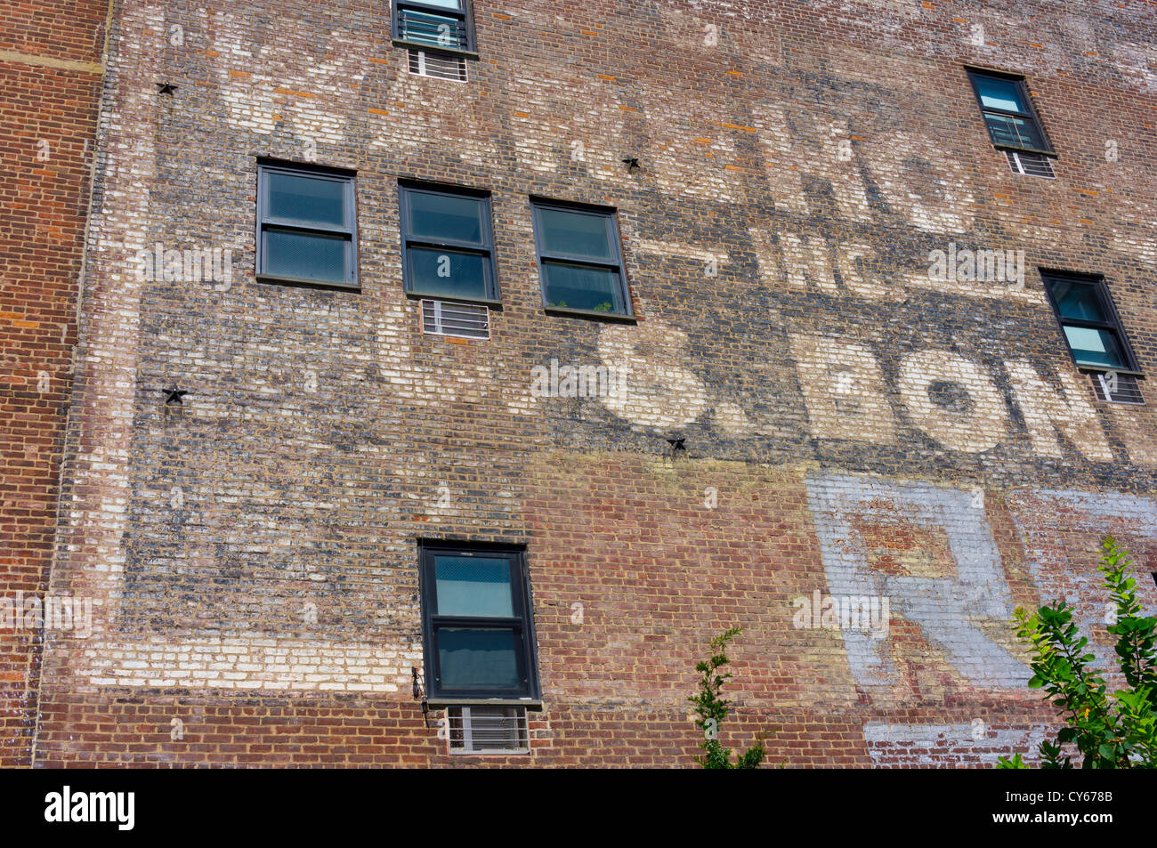 The wall of a former warehouse with faded sign writing seen from the High Line city park, New York. Stock Photo