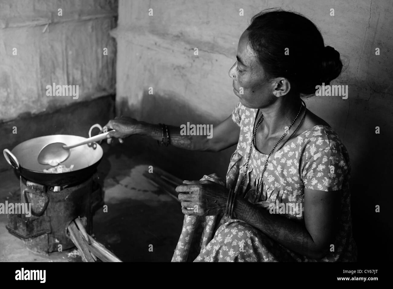 Local woman cooking in typical village kitchen, Goutali village, Chitwan National Park, Nepal Stock Photo