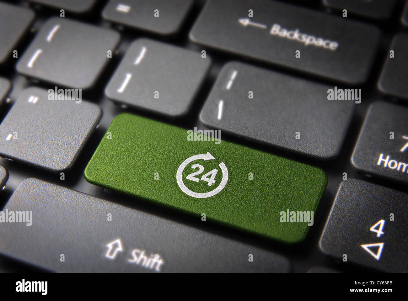 Online business always open concept: green key with 24 working hours symbol on laptop keyboard. Included clipping path, so you can easily edit it. Stock Photo
