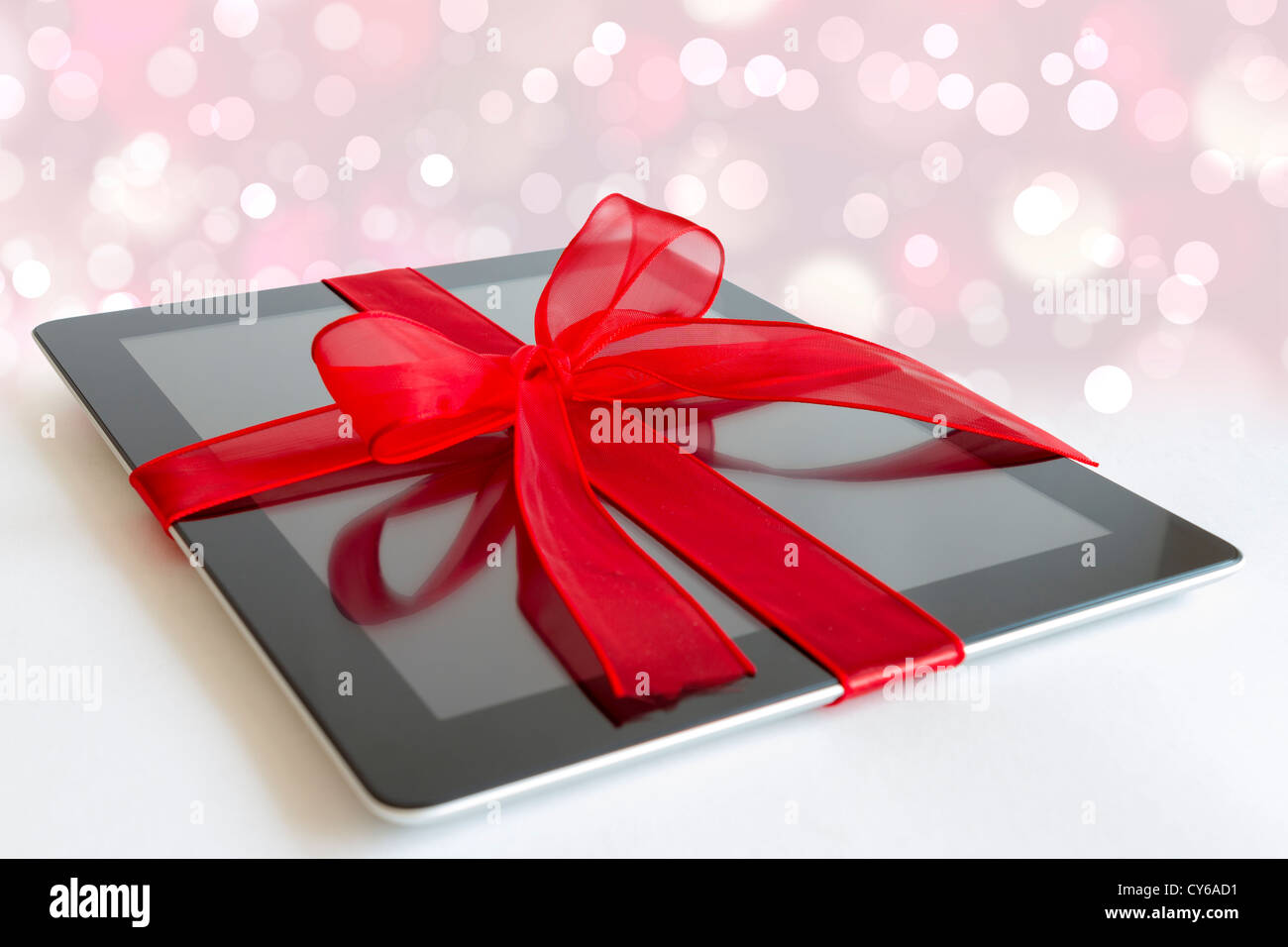 Digital tablet with red ribbon gift isolated on white Stock Photo Alamy