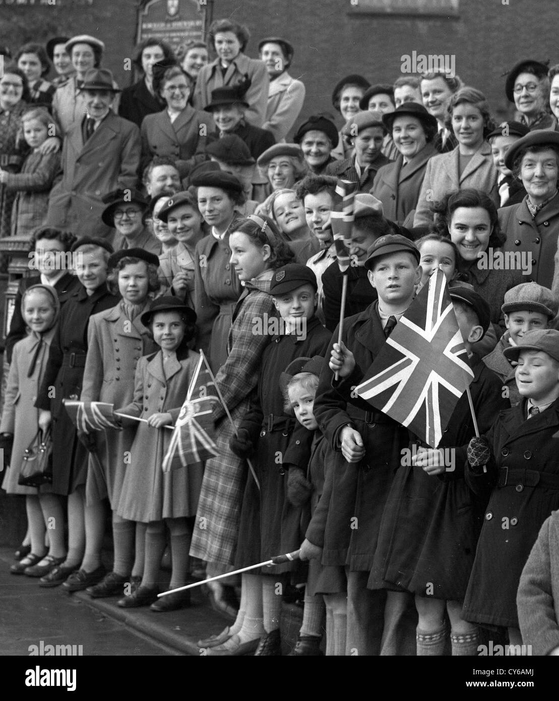 Crowds line the streets for the Queen's visit to Shrewsbury on Friday October 24th 1952. Britain 1950s people school children families royal visit patriotic flag waving royalists Stock Photo