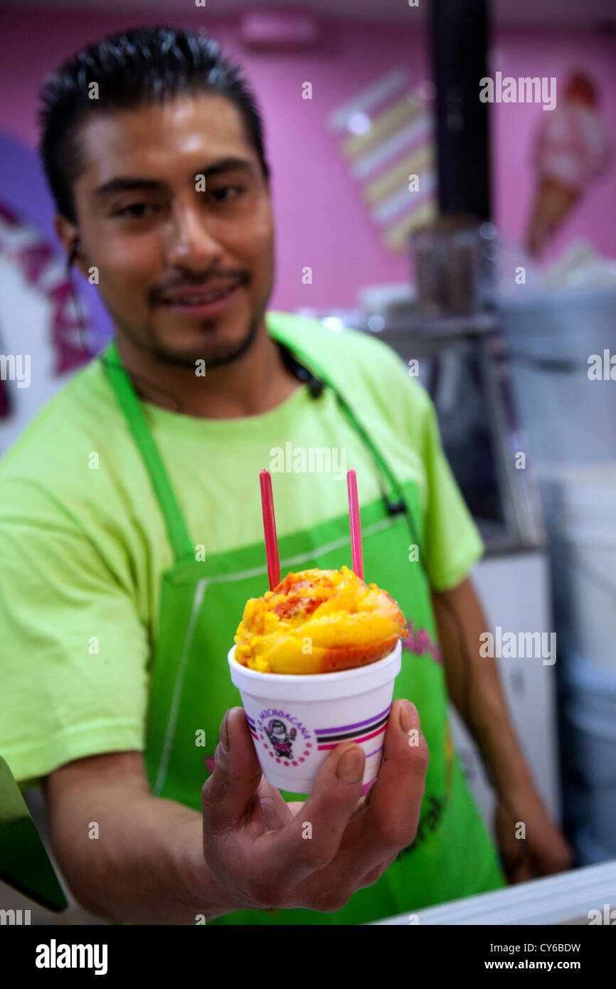 Sorbet of Mango and Chili Being Offered By employee of La Michoacana brand at Jamaica Market - Mexico City DF Stock Photo