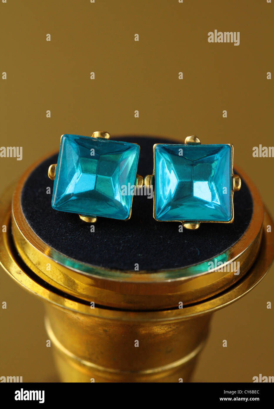 gold earrings stud with diamonds on gold background Stock Photo - Alamy