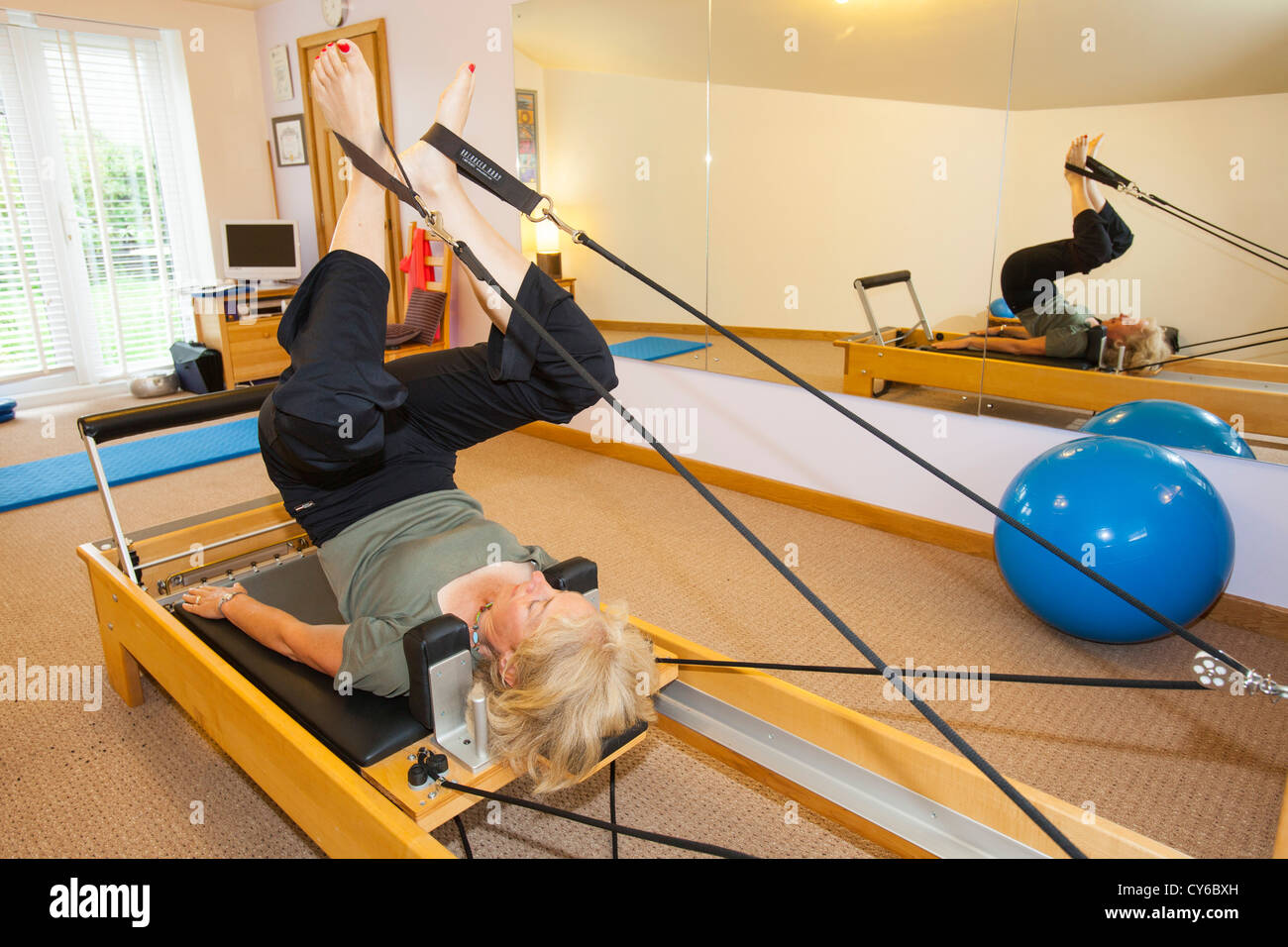 A Pilates instructor using a pilates reformer machine Stock Photo Alamy