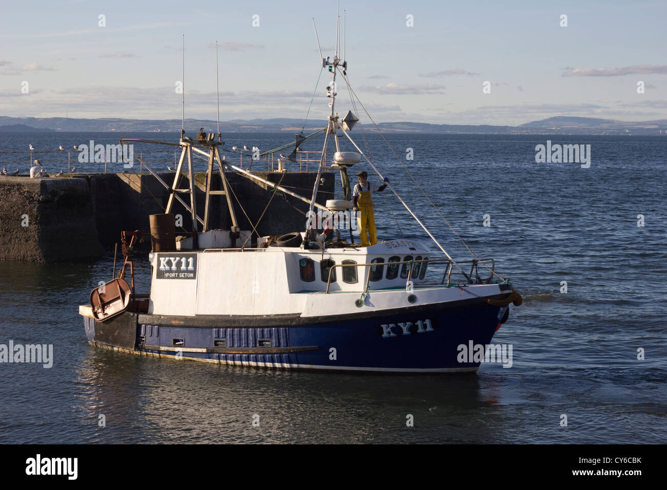 Fishing boat leaving Port Seton harbour Stock Photo