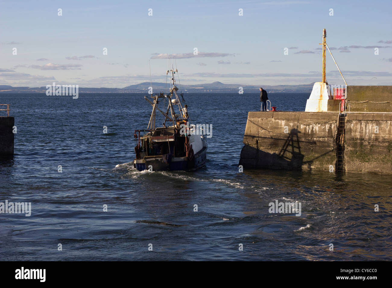 Fishing boat leaving Port Seton harbour Stock Photo