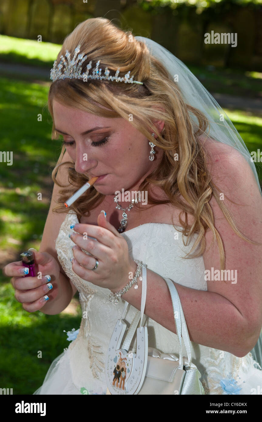 Model Released bride smoking a cigarette at the wedding Stock Photo
