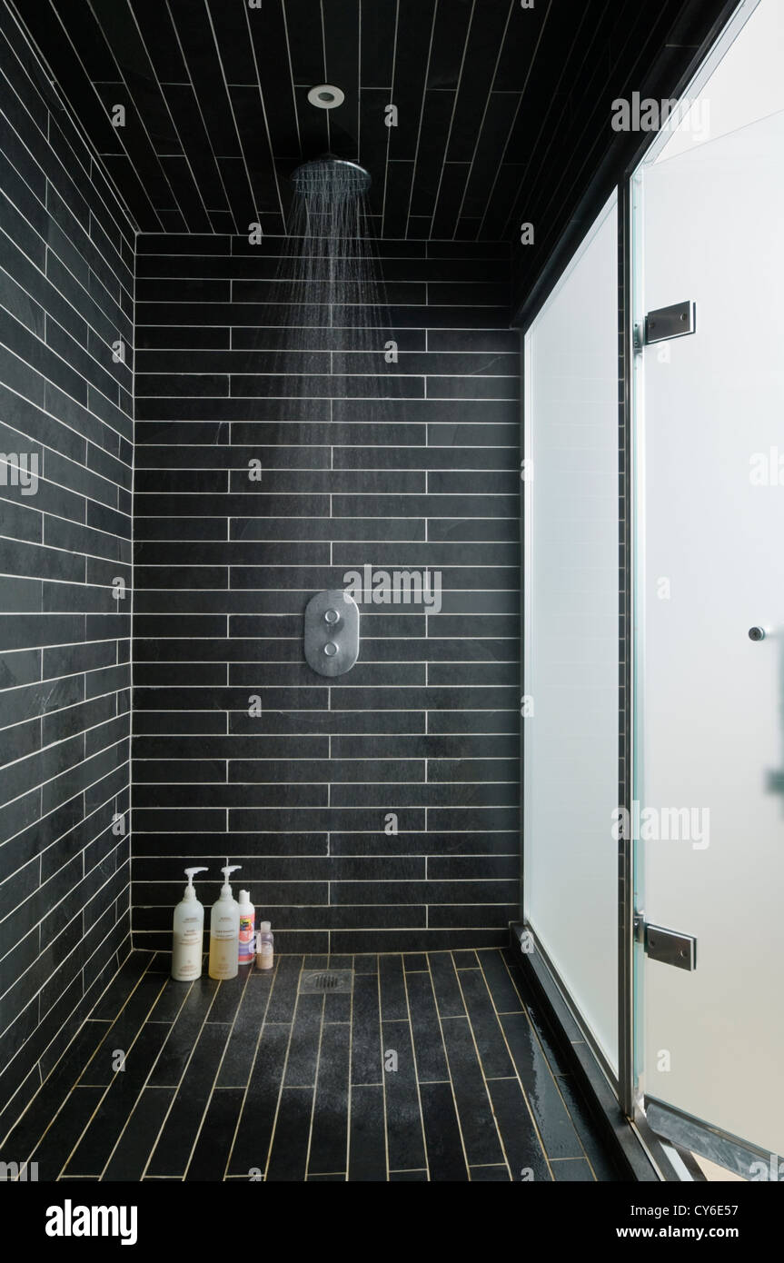 Black tiled wet room with running power shower Stock Photo