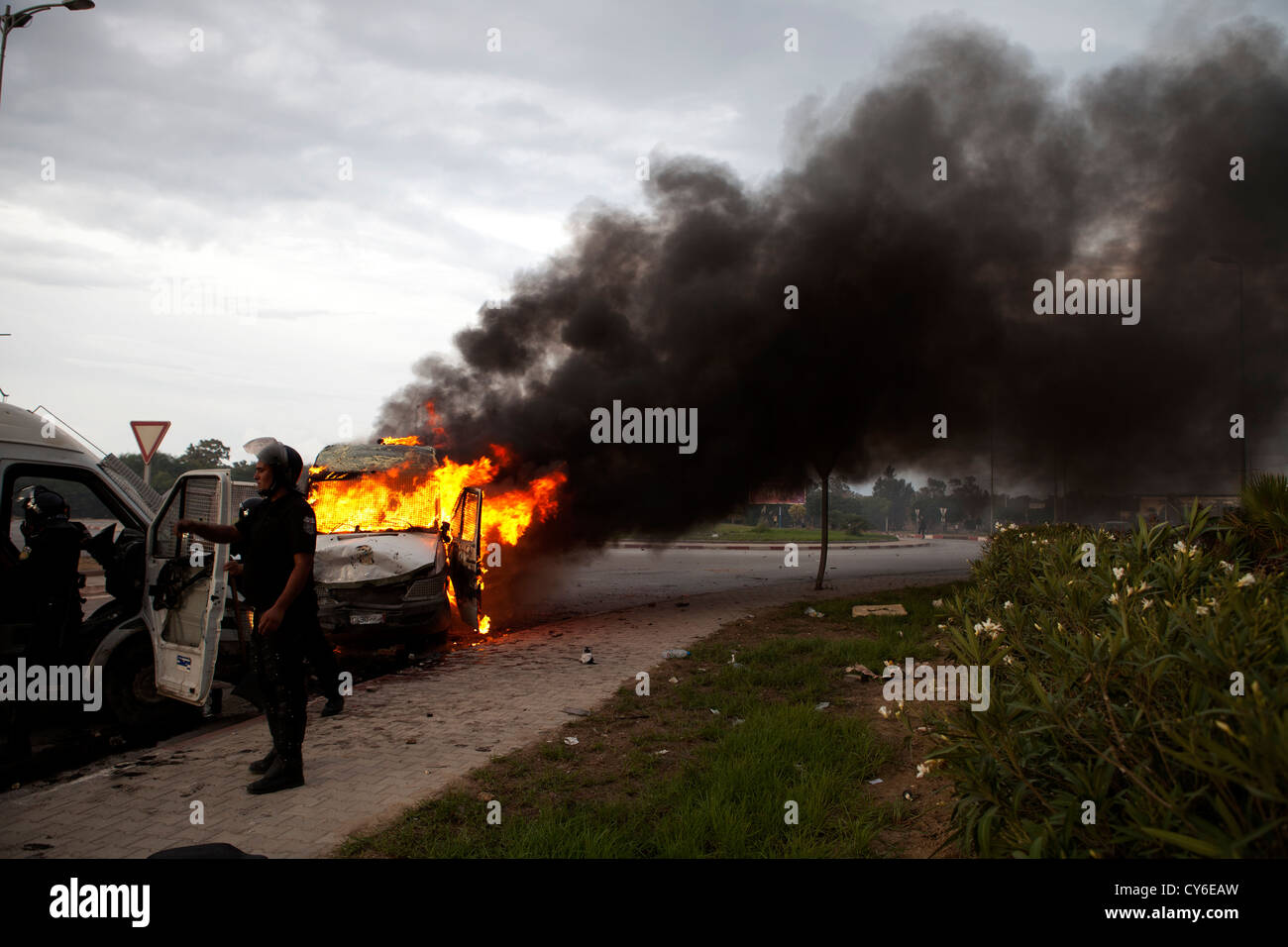 A police car burns close to the US embassy in Tunis after being struck by a Molotov cocktail during the storming of the embassy Stock Photo