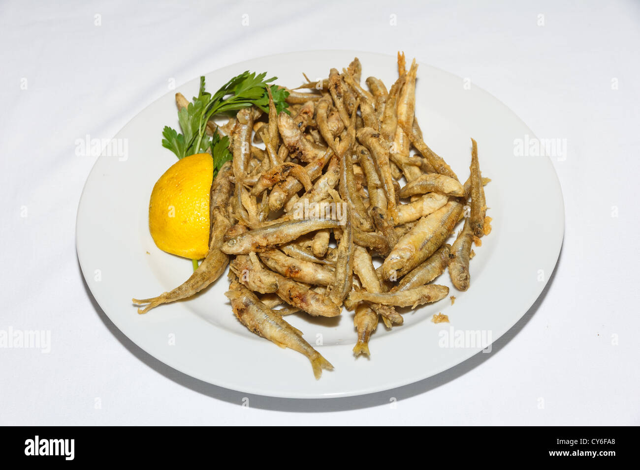 https://c8.alamy.com/comp/CY6FA8/small-fried-fishes-on-a-plate-with-lemon-a-tasty-and-crunchy-dish-CY6FA8.jpg