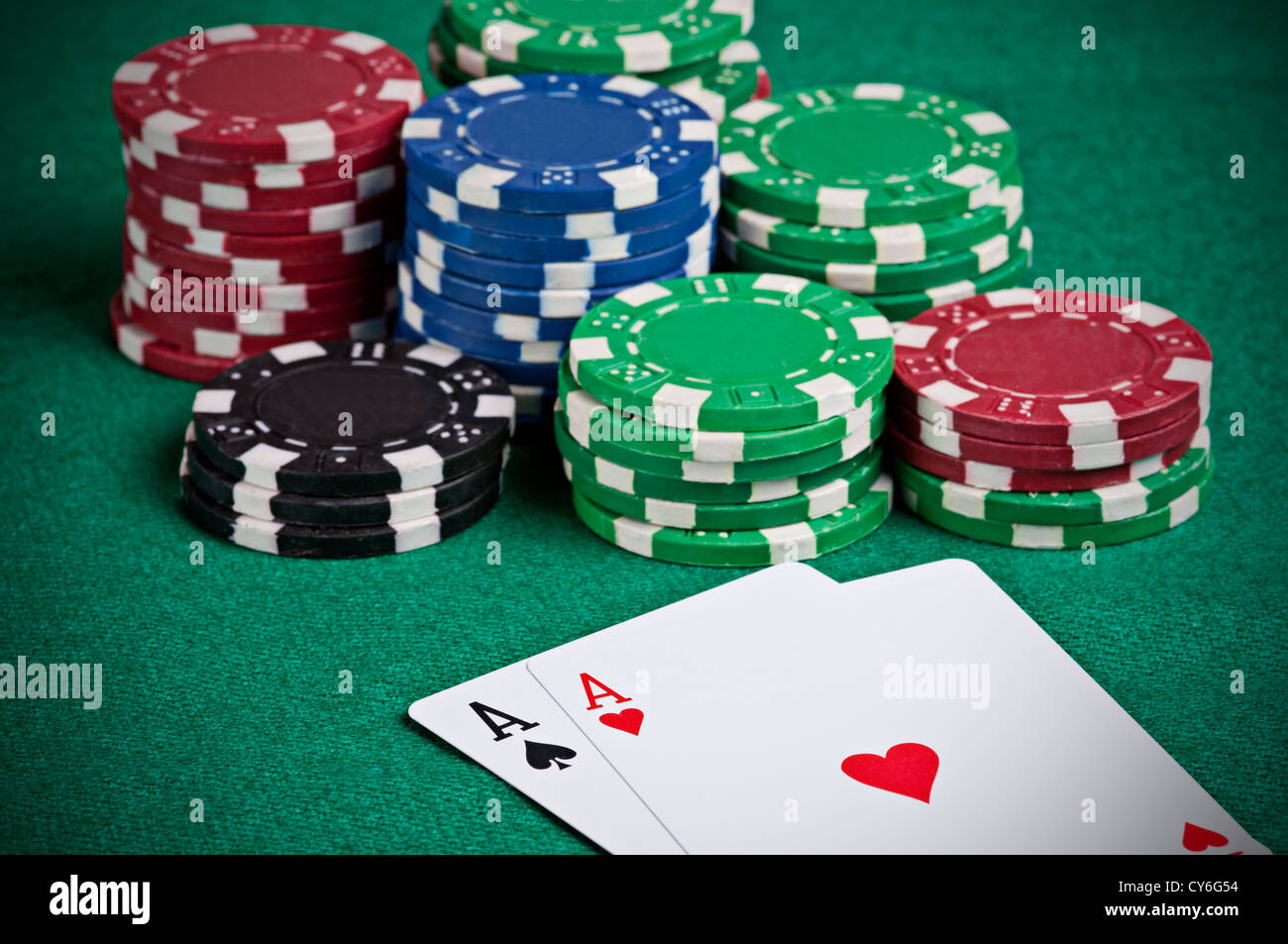 Pair of aces on a poker table with poker chips next to them Stock Photo