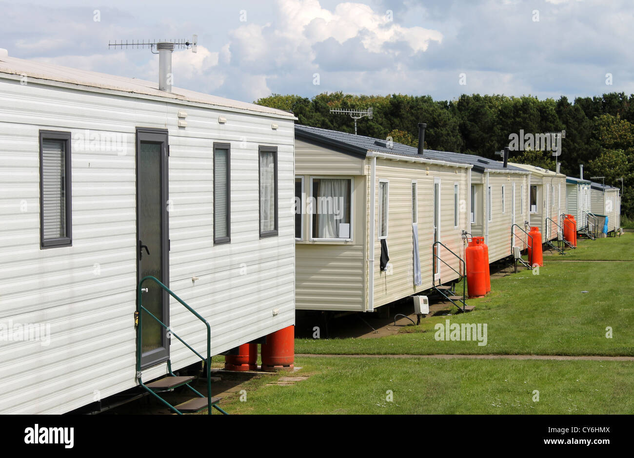Row of caravan trailers in holiday park with cloudscape background. Stock Photo