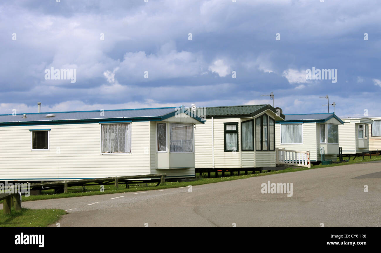 Row of caravan trailers in holiday park with cloudscape background. Stock Photo