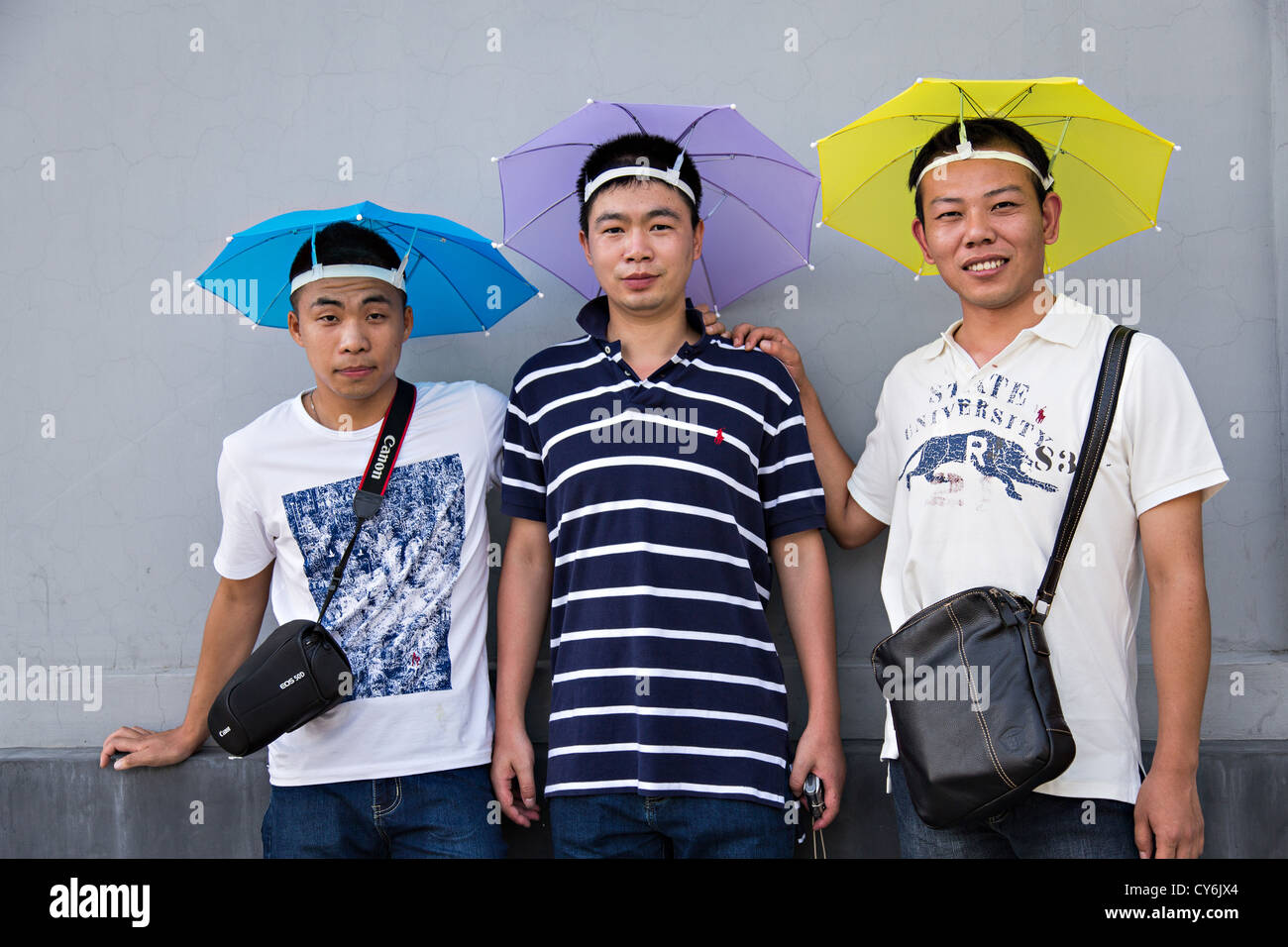 A group of Chinese tourists wearing umbrella hats in Beijing, China Stock Photo