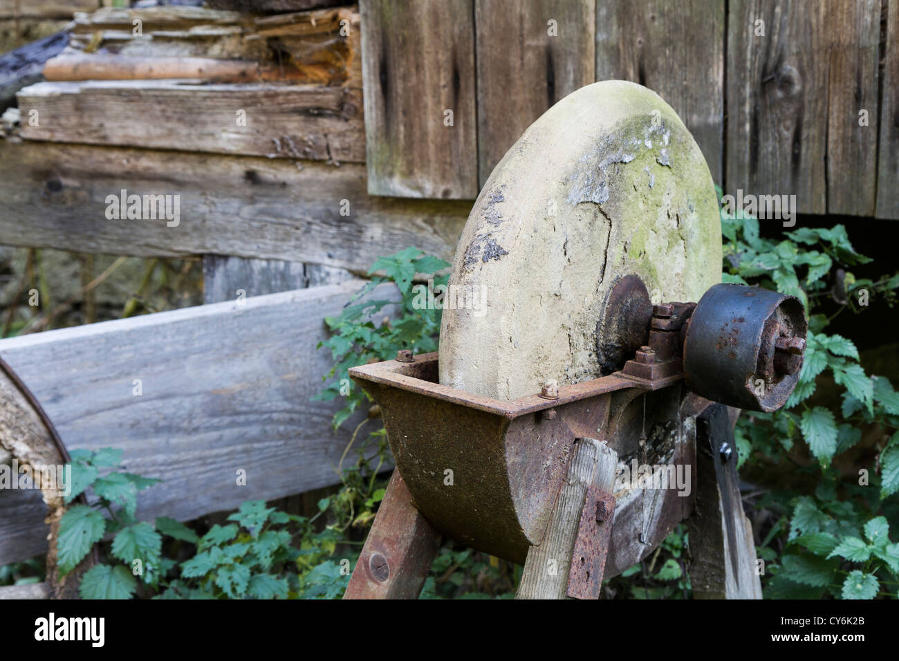 old, used grinding stone in romantic background Stock Photo