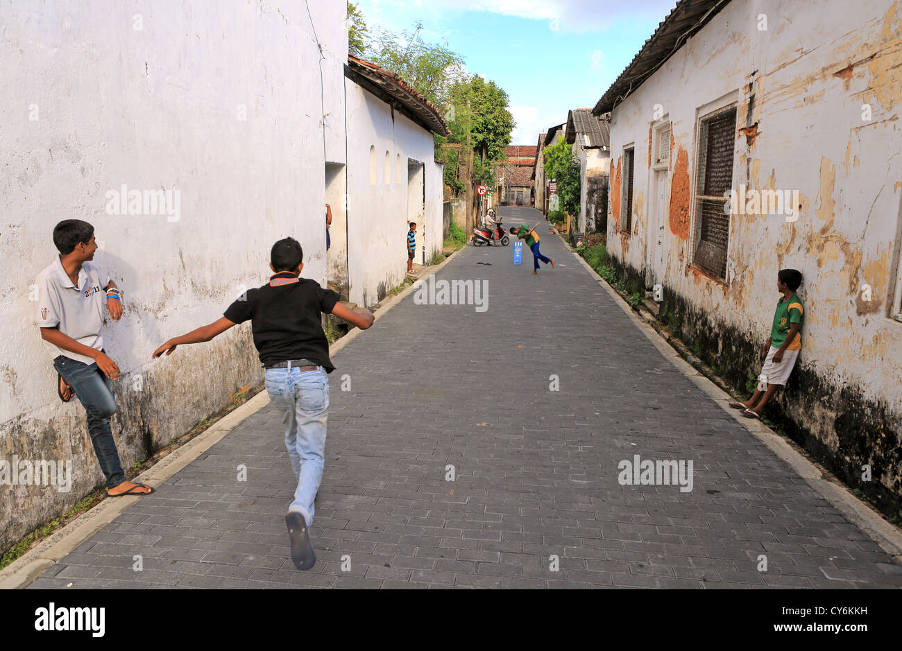 Sri Lankan boys playing cricket in the street inside Galle Fort. Stock Photo