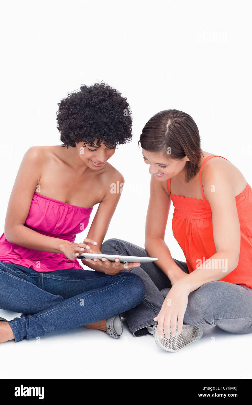 Teenagers attentively looking at a tablet computer against a white background Stock Photo