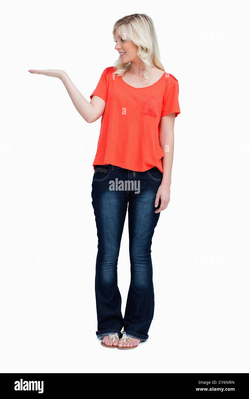 Smiling teenager standing upright with her hand palm up Stock Photo
