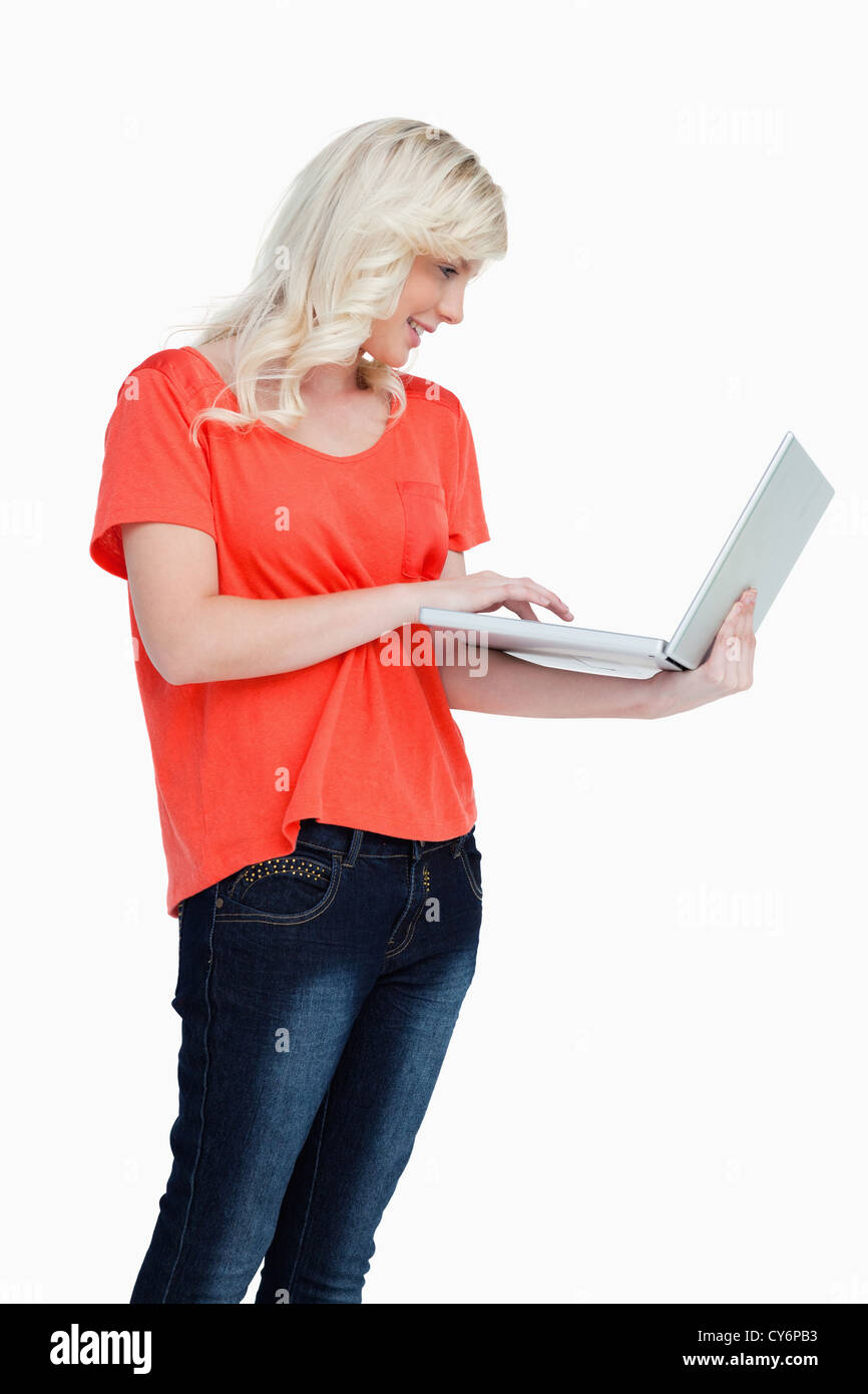 Woman standing upright while using the touchpad of her laptop Stock Photo