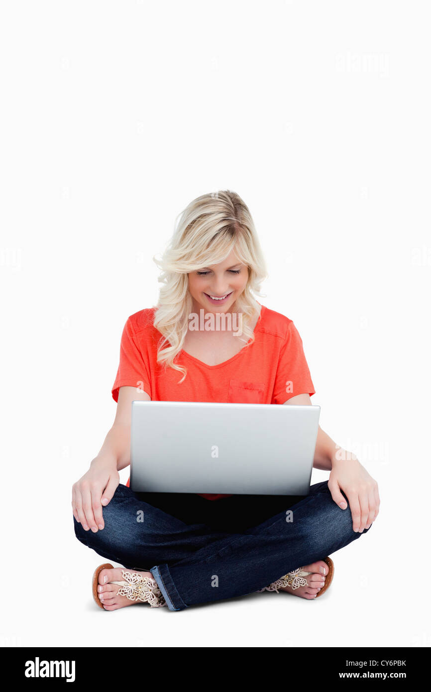 Attractive fair-haired woman sitting cross-legged with her hands on legs Stock Photo