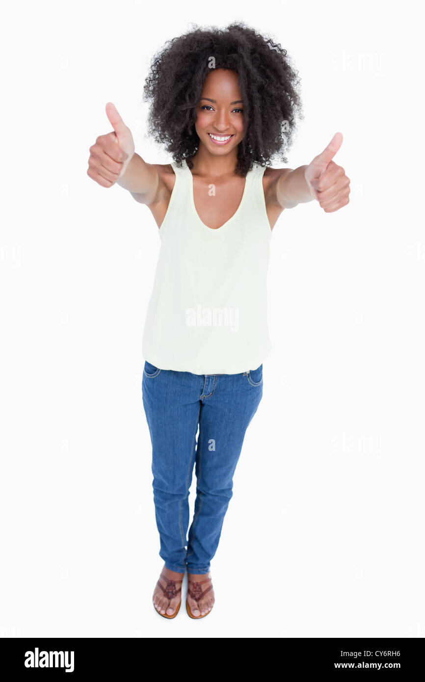 Young relaxed woman standing upright with her thumbs up Stock Photo