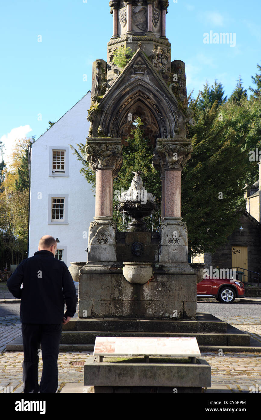 Dunkeld Perhshire - Man looking at the historical information about Atholl Memorial Fountain sited at the Cross or town Square Stock Photo