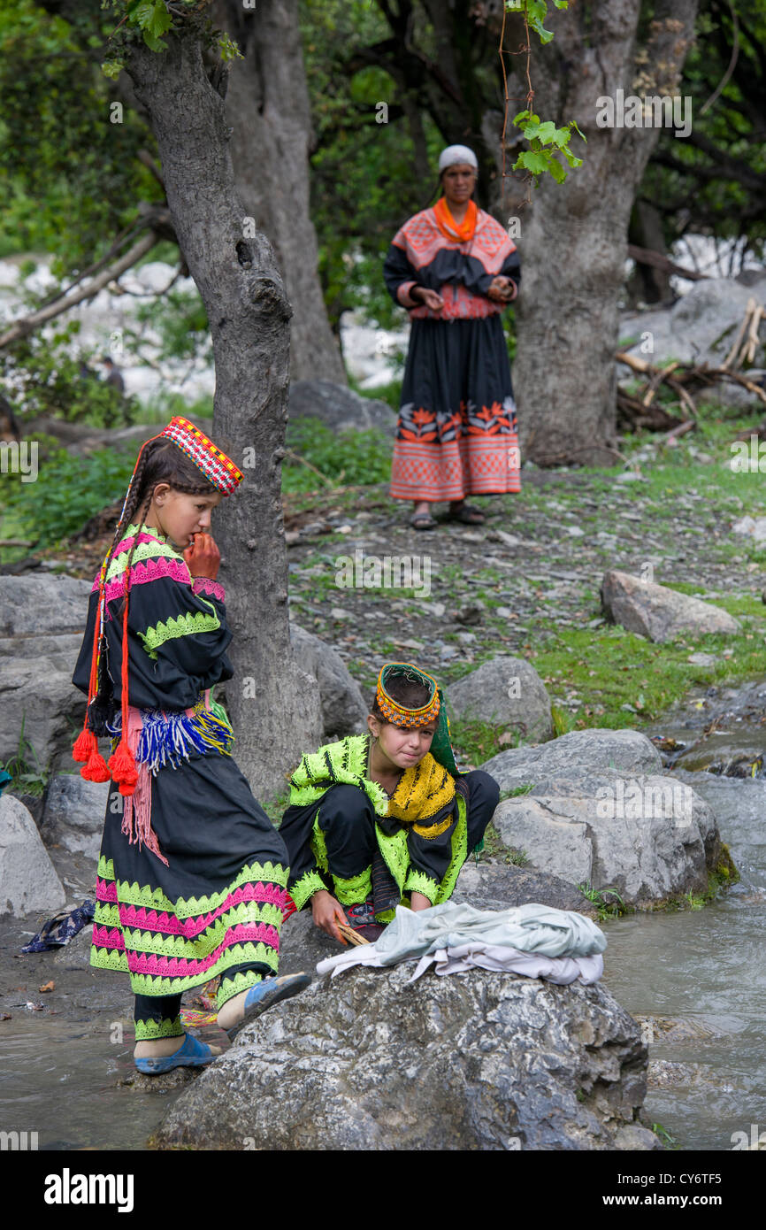 Kalash girls washing clothes in the stream running through the village