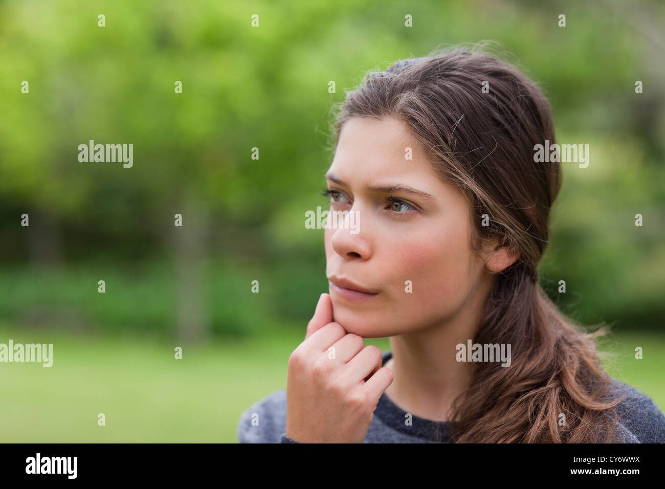 Young thoughtful girl standing upright in the countryside Stock Photo