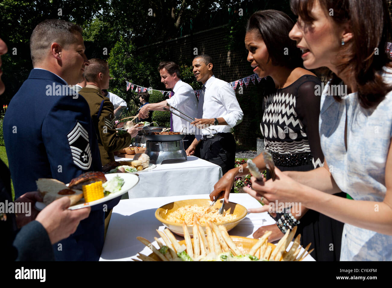US President Barack Obama, British Prime Minister David Cameron, First Lady Michelle Obama, and Samantha Cameron serve military families during a barbecue in the garden at 10 Downing Street May 25, 2011 in London, England. Stock Photo