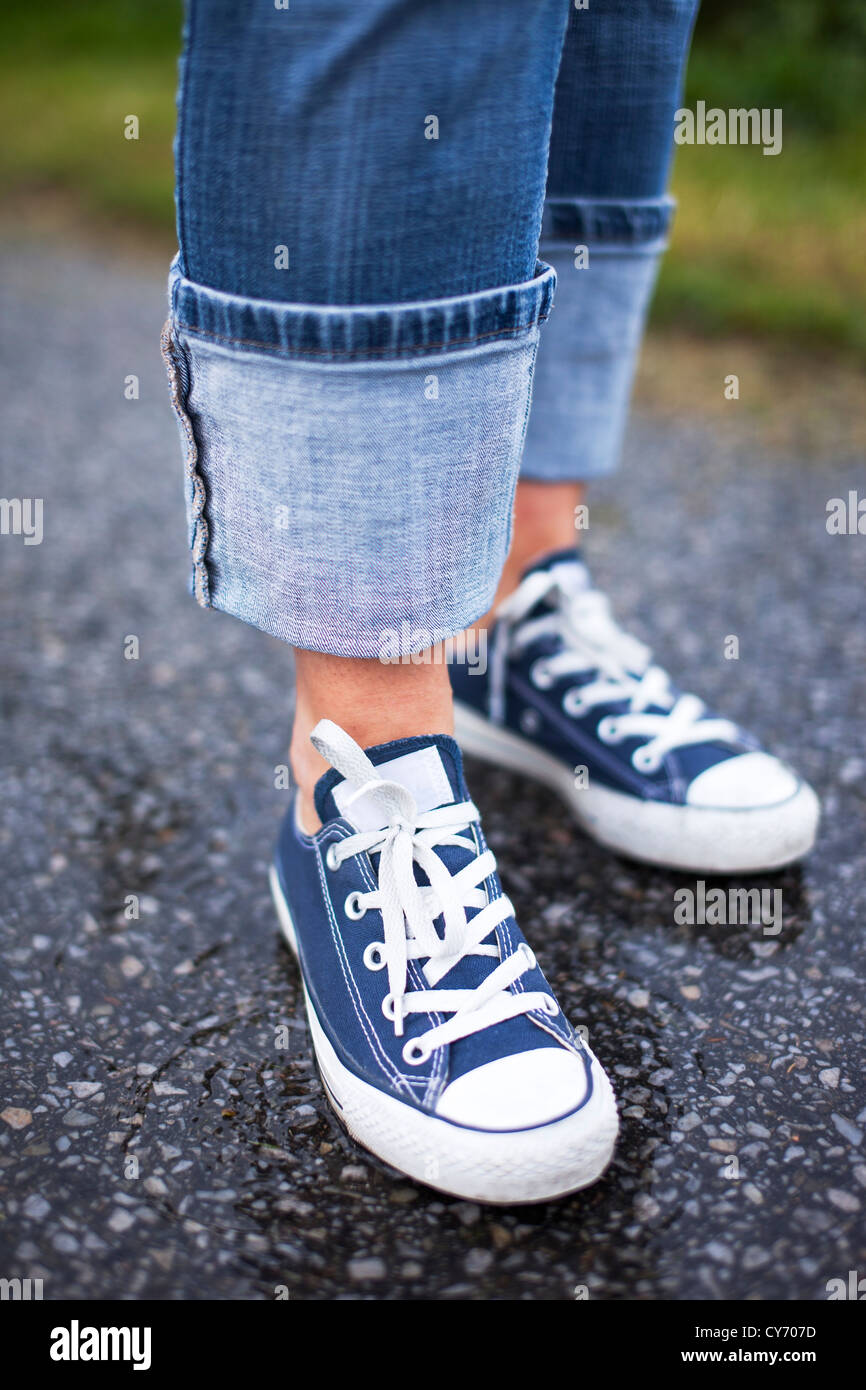 Close up of a pair of blue sneakers and blue jeans on a wet ground Stock  Photo - Alamy