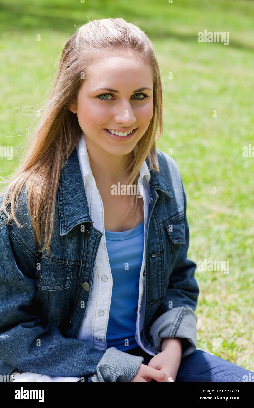 Young attractive girl sitting on the grass in a park Stock Photo - Alamy